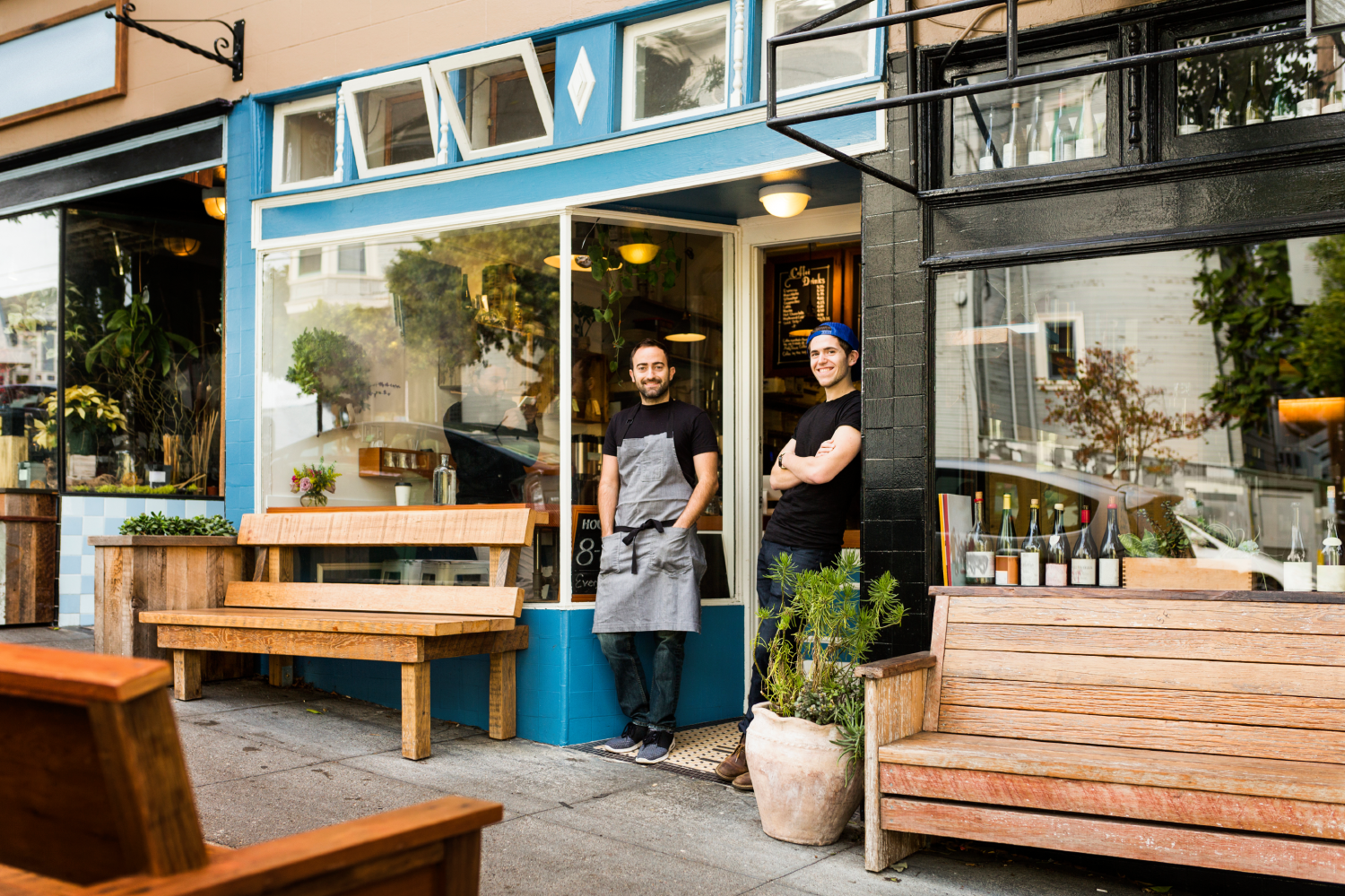 portrait-of-two-young-men-standing-by-coffee-shop